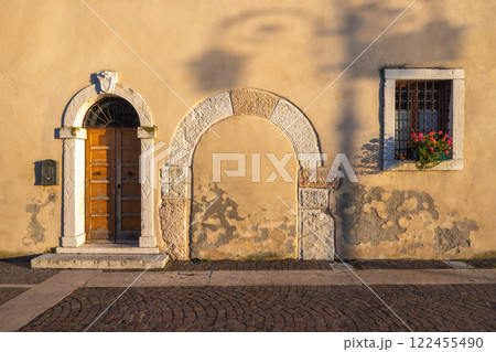 Facade of an old house in Lazise town on shore of Lake Garda at sunset, Italy, Europe. 122455490
