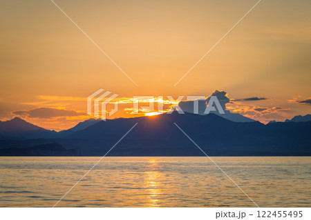 Lake Garda with mountains in background at sunset, view from Lazise town shore, Italy, Europe. Lake Garda with mountains in background at sunset, view from Lazise town shore, Italy, Europe. 122455495