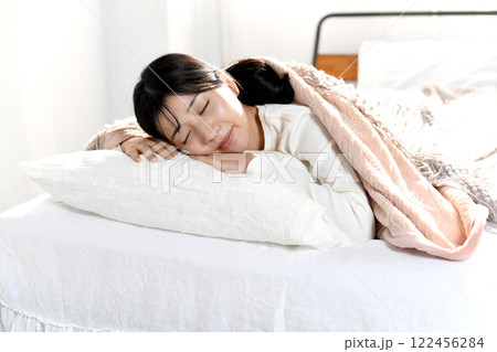 ベッドでうつ伏せで寝るアジア人の若い女性 ベッドでうつ伏せで寝るアジア人の若い女性 122456284