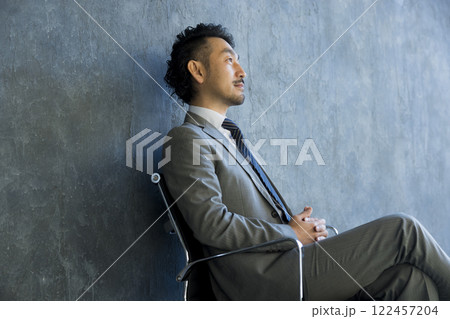 椅子に座ったスーツの男性 122457204