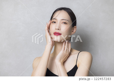 頬に手を当てる若い女性 122457283