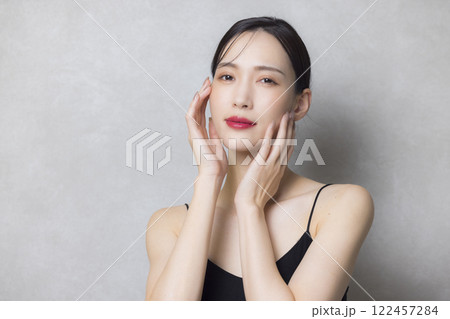 頬に手を当てる若い女性 122457284