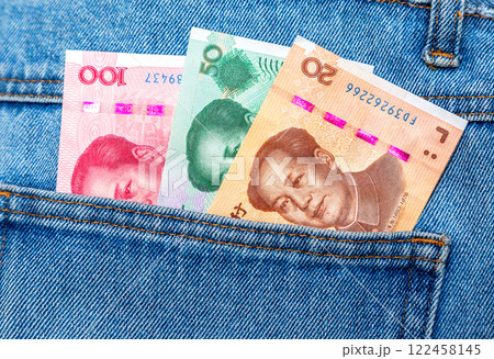 Chinese yuan banknotes sticking out of the pocket of jeans 122458145