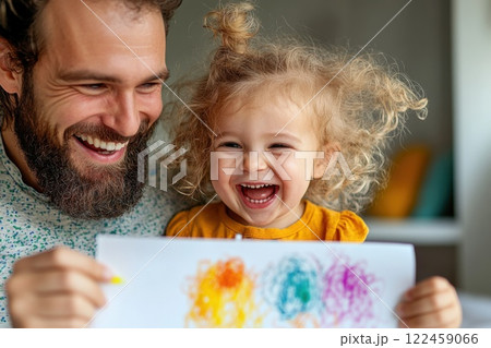 Child proudly displays first drawing to smiling parent in cozy home setting 122459066