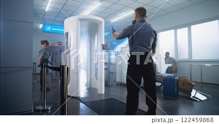 Mature Man Passes Through Metal Detector Scanner. Security Officer Checks Passenger for Plane Flight Mature Man Passes Through Metal Detector Scanner. Security Officer Checks Passenger for Plane Flight 122459868