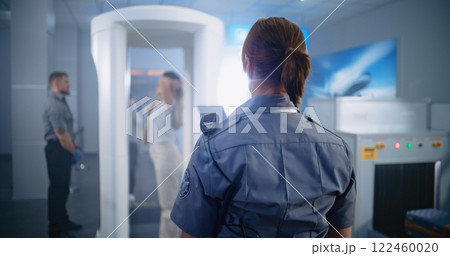 Back View of Female Security Officer Controlling Passenger Scanning for Plane Flight 122460020