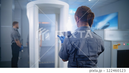 Woman Passes Through Metal Detector Scanner. Female Security Officer Checks Passenger, Ticket 122460123