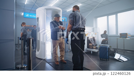 Elderly Man Walks Through Metal Detector Gates. Security Officer Checks Passenger and Documents 122460126