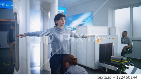 Woman Passes Through Metal Detector Scanner Gates. Female Security Officer Checks Passenger 122460144