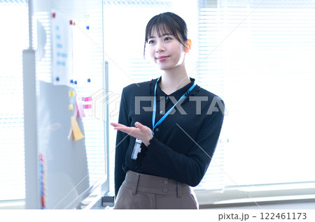 ホワイトボードを使ってプレゼンテーションする若いビジネスウーマン ホワイトボードを使ってプレゼンテーションする若いビジネスウーマン 122461173