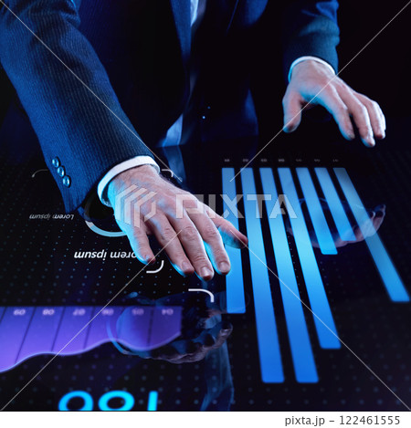 Businessman in dark suit placing both hands on digital touch interface with illuminated bar graphs and data points against dark background. 122461555