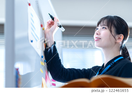 ホワイトボードにプレゼン内容を書き込む若いビジネスウーマン 122461655