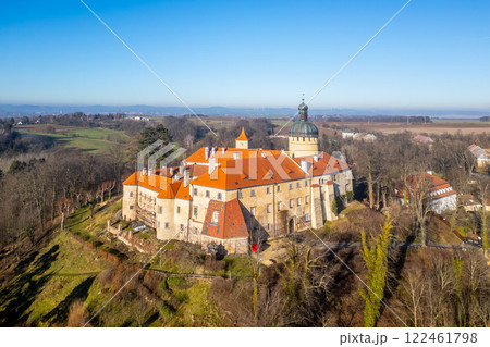 Grabstejn castle stands majestically against a clear blue sky, surrounded by lush green hills. The sun illuminates its historic architecture, inviting visitors to explore its rich history. 122461798