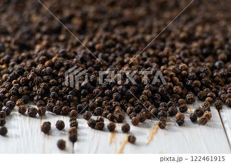 black pepper seeds on a white wooden table, selective focus. 122461915