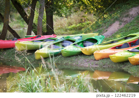 Many canoes of different colors on the river bank before training without people. Boating on the city river 122462219