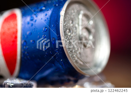 Close-up of a can of coca cola. Pepsi advertisement. Iron can of cola on a table with ice cubes Close-up of a can of coca cola. Pepsi advertisement. Iron can of cola on a table with ice cubes 122462245