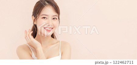 Smiling young woman with flawless skin posing against a pastel background, promoting beauty, skincare, and confidence. Smiling young woman with flawless skin posing against a pastel background, promoting beauty, skincare, and confidence. 122462711