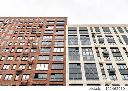 Contemporary multi-story buildings with beige, red brick and glass facades, balconies and windows. Urban architecture concept, low angle view Contemporary multi-story buildings with beige, red brick and glass facades, balconies and windows. Urban architecture concept, low angle view 122462910