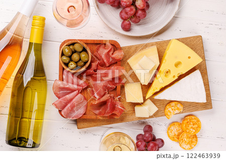 A delectable arrangement of various cheeses, fresh grapes, prosciutto and wine 122463939
