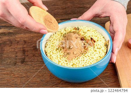 Sprinkling instant noodles with a mixture of pepper and salt. Sprinkling instant noodles with a mixture of pepper and salt. 122464794