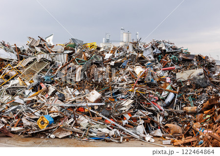 Scenic metal scrap yard huge pile of rusty metal parts disposal waste at junkyard recycling site against industrial factory plant area at Germany. Scrapyard waste management industry background 122464864