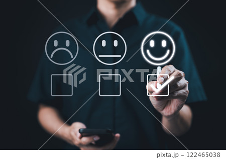 Customer satisfaction and feedback survey concept. A person select happy face, indicating positive feedback in customer satisfaction survey. customer experience evaluation and feedback collection. Customer satisfaction and feedback survey concept. A person select happy face, indicating positive feedback in customer satisfaction survey. customer experience evaluation and feedback collection. 122465038