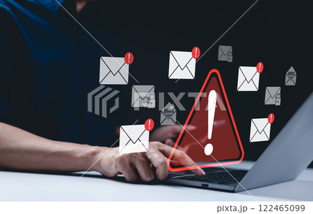 Email security warning notification concept. A person using laptop with email security alert icons and warning notifications, indicating cybersecurity threats such as spam, viruses, junk mail, scams, 122465099
