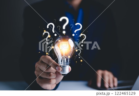 Question mark and problem solving concept. Glowing lightbulb with question marks, symbolizing ideas, problem-solving, and brainstorming. It conveys innovation, curiosity, and search for solutions. 122465129