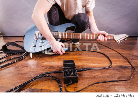 Man setting up guitar equipment Man setting up guitar equipment 122465468