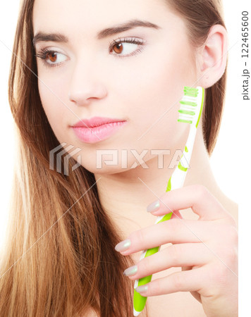 Woman holding toothbrush, thinking about hygiene Woman holding toothbrush, thinking about hygiene 122465600