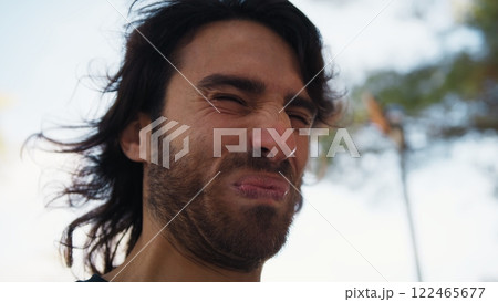 Long Hair Man Chews Sour Lemon and Makes Disgusted Facial Expressions Outdoors Long Hair Man Chews Sour Lemon and Makes Disgusted Facial Expressions Outdoors 122465677