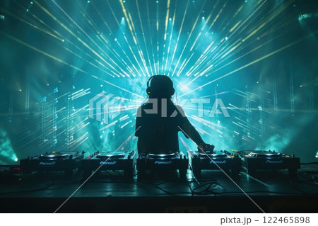 Female DJ Mixing Electronic Dance Music at a Nightclub with Laser Lights in the Background 122465898