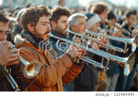 Vibrant group of talented trumpet players performing lively music outdoors under the bright sun 122465945