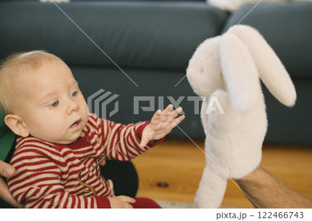 Adorable Baby Engaging Playfully with a Soft and Cuddly Bunny Toy While Smiling Joyfully Adorable Baby Engaging Playfully with a Soft and Cuddly Bunny Toy While Smiling Joyfully 122466743