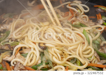 鉄板で肉と野菜とうどんを炒める 122467532