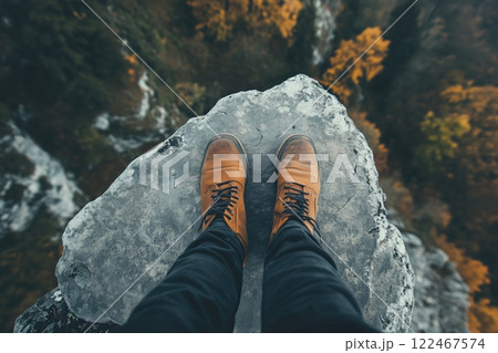 Man or woman in hiking boots standing on the edge of dangerous stone rock. Nature and travel concept Man or woman in hiking boots standing on the edge of dangerous stone rock. Nature and travel concept 122467574
