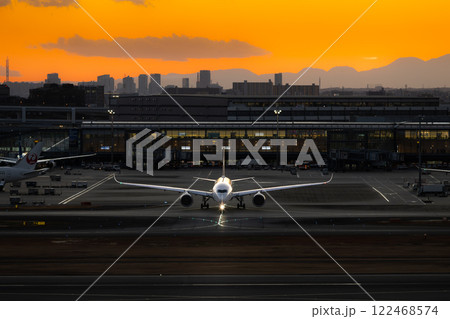 夕焼けの羽田空港とタキシングする飛行機 夕焼けの羽田空港とタキシングする飛行機 122468574
