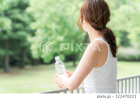 公園・森林の中でミネラルウォーターを飲む若いアジア人女性 公園・森林の中でミネラルウォーターを飲む若いアジア人女性 122470221