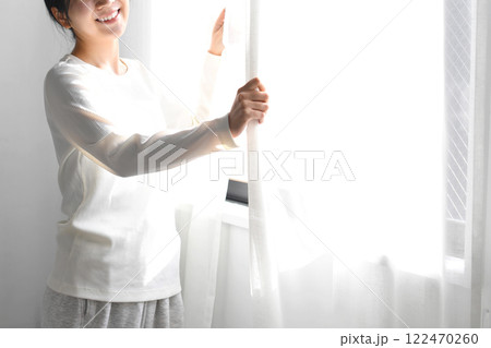 カーテンを開け日光を浴びるアジア人女性 カーテンを開け日光を浴びるアジア人女性 122470260