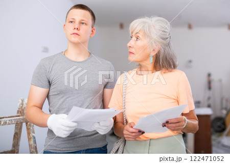 Teenager helping senior woman with home improvement works 122471052