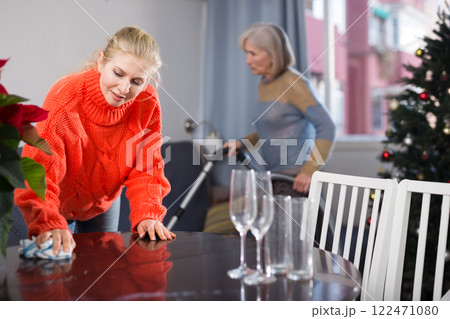 Adult daughter and her mature mother clean the flat 122471080
