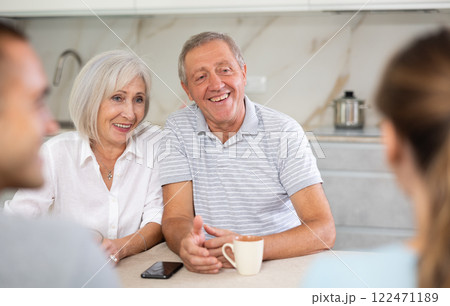 Family of four sits at table and talking Family of four sits at table and talking 122471189