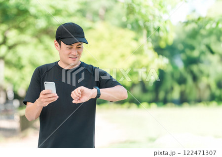 スマートウォッチを使い健康管理・ヘルスケアをするスポーツウェア姿の中年男性 122471307