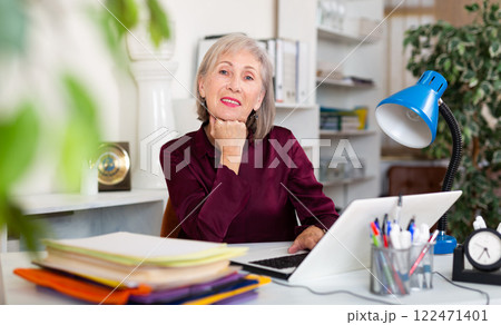 Positive mature woman working at office Positive mature woman working at office 122471401