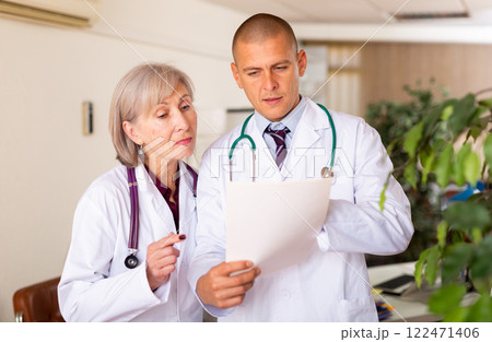 Two doctors discussing medical documentation Two doctors discussing medical documentation 122471406