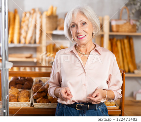 Mature female customer choosing bread and other delicious pastries in bakery 122471482
