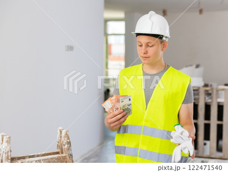 Portrait of a contented fifteen-year-old worker with the first salary Portrait of a contented fifteen-year-old worker with the first salary 122471540