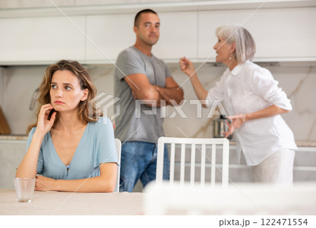 Elderly woman quarrels with couple in kitchen 122471554