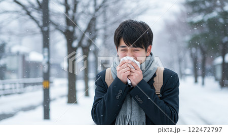 クシャミをしている若い日本人男性 122472797