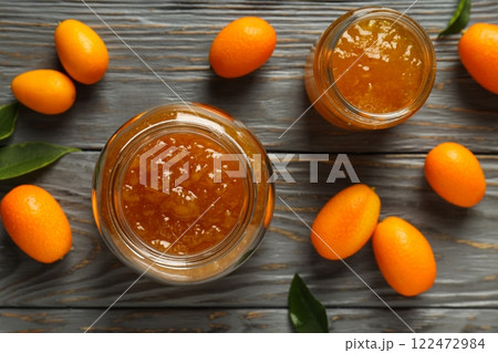 Kumquat and jars of jam on wooden background, top view 122472984